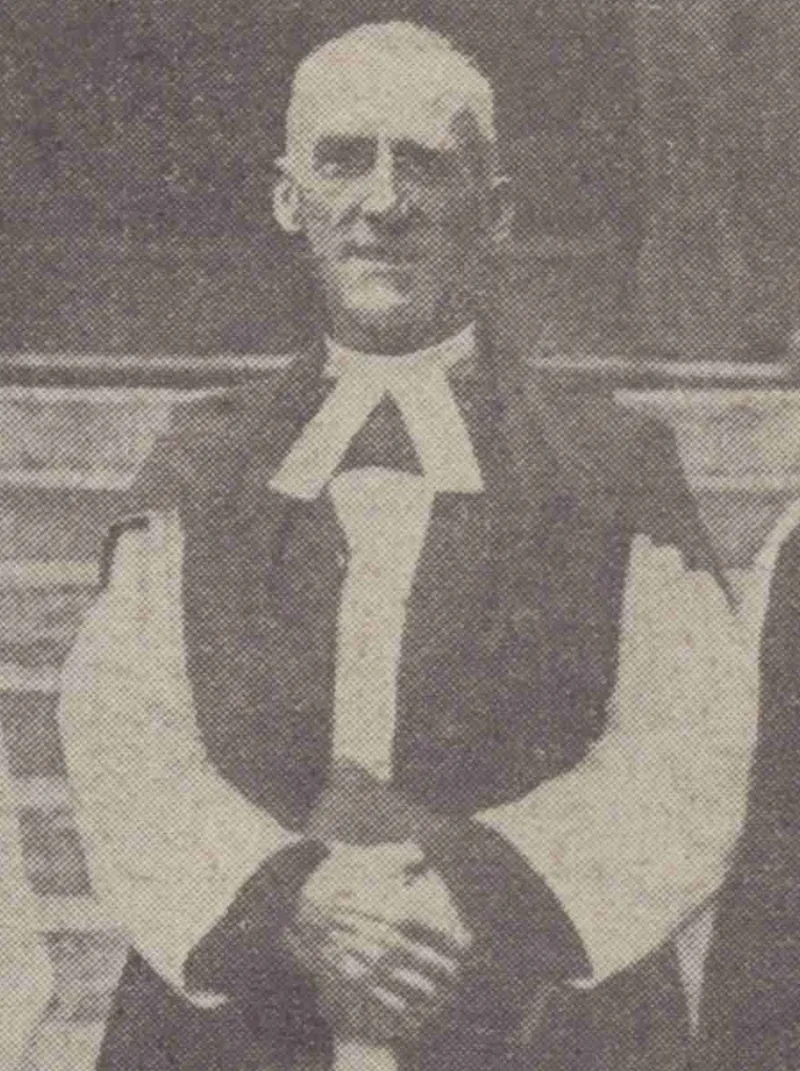 Fotografía de prensa de 1923: un obispo recién consagrado en la abadía de Westminster, con roquete blanco y muceta negra, las manos juntas